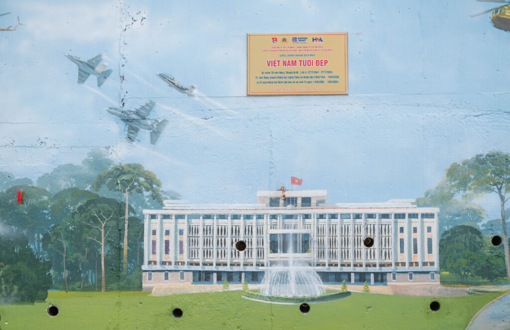 Close-up of the community mural featuring landmark architecture and a Beautiful Vietnam commemorative plaque.
