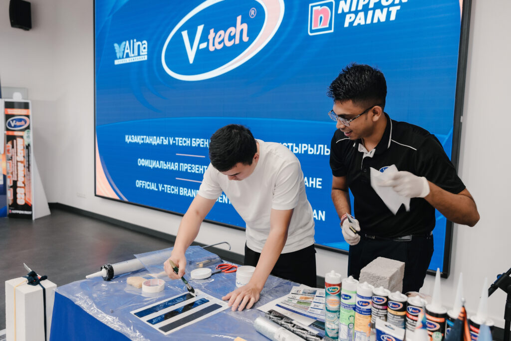 Two men demonstrating the application of V-tech MS polymer sealants during a practical workshop in Almaty.